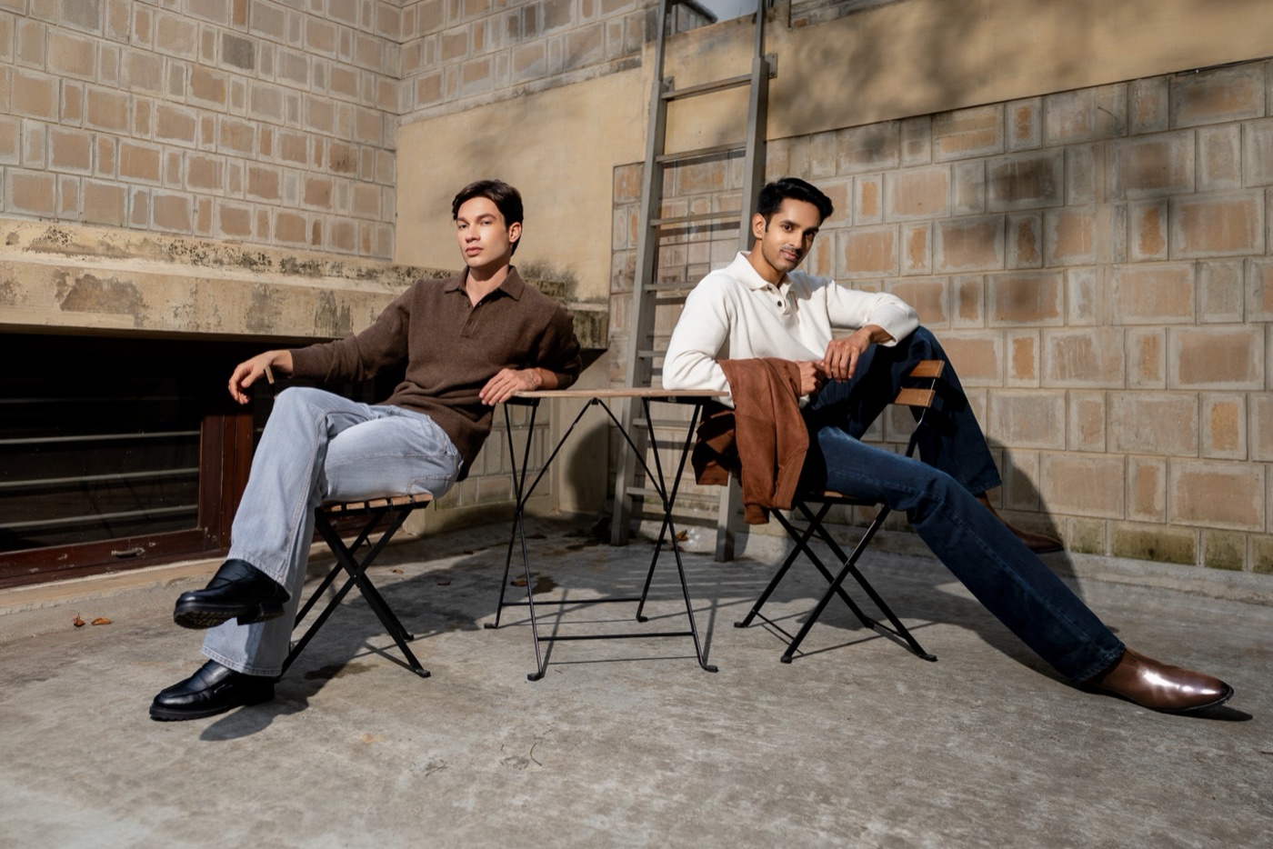 Two men seated at a café table in SUOS denim