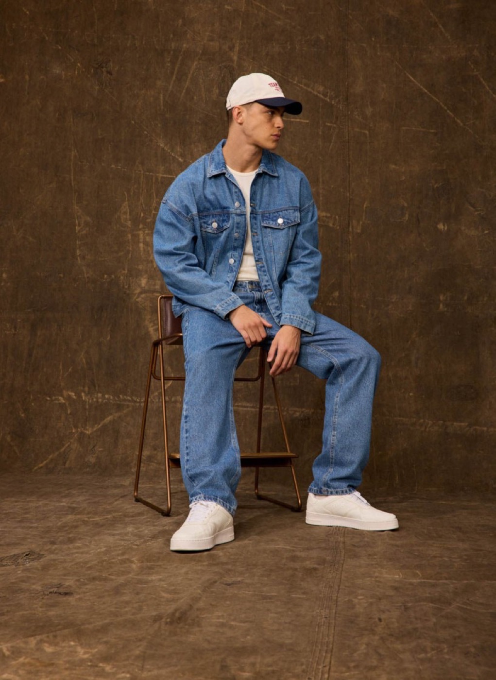 Model in a denim set on a chair