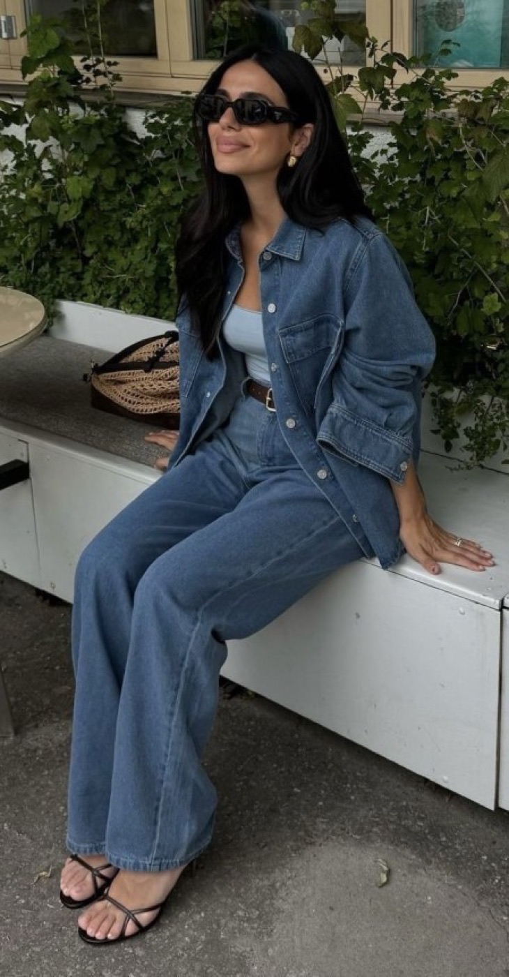 Model in denim beside greenery